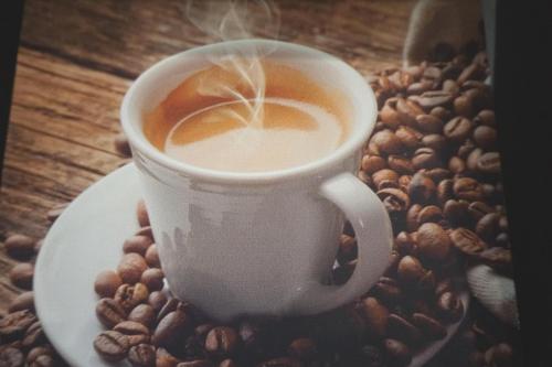 a cup of coffee on a plate with coffee beans at 50180... in Harlesiel