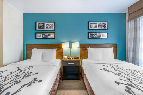 two beds in a hotel room with blue walls at Sleep Inn near Washington State Line in Post Falls