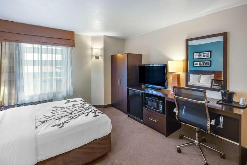 a hotel room with a bed and a desk and a television at Sleep Inn near Washington State Line in Post Falls