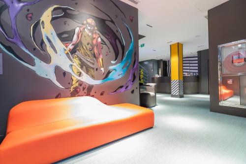 an orange bed in a room with a painting on the wall at MYR Plaza Mercado & Spa in Valencia