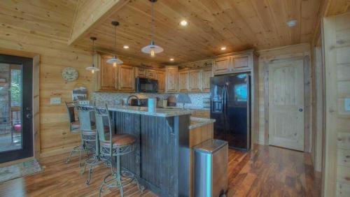 Una cocina con gabinetes de madera y un refrigerador negro. en Above and Beyond, en Blue Ridge
