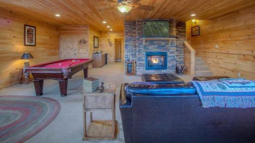 Una sala de estar con mesa de billar y chimenea. en Black Dog of Blue Ridge, en Blue Ridge