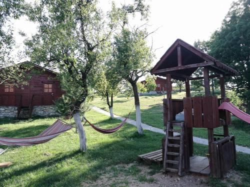 a playground with two hammocks in a yard at Pensiunea Gernik 100 in Gârnic