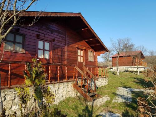 a log cabin with a porch and stairs to it at Pensiunea Gernik 100 in Gârnic