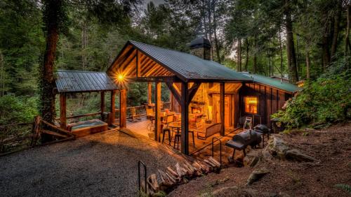 a wooden cabin in the woods with a light on at Creekside R&R in Blue Ridge