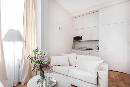 a white living room with a white couch and a table at Luxury Apartment 60 in Warsaw