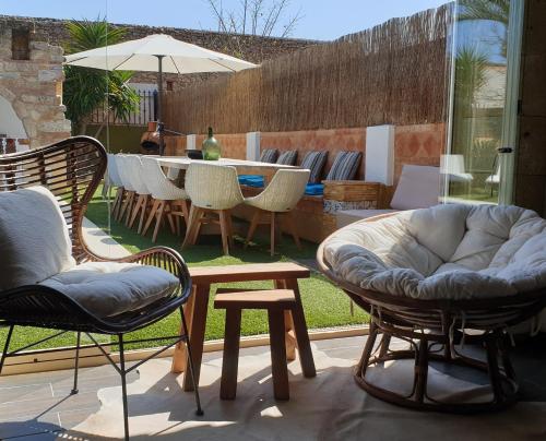 a patio with chairs and a table and a table and chairs at Casa Mistela in Jalón