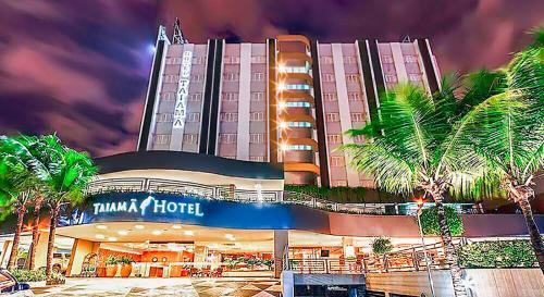 um grande hotel com palmeiras em frente em Amazon Taiamã Hotel em Cuiabá