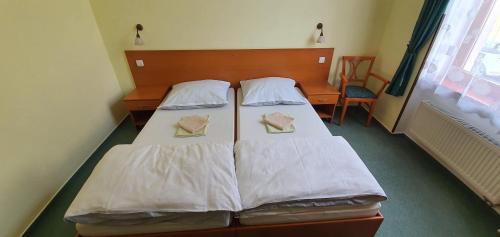 a bedroom with two beds with white sheets at Penzión Rodina in Levoča