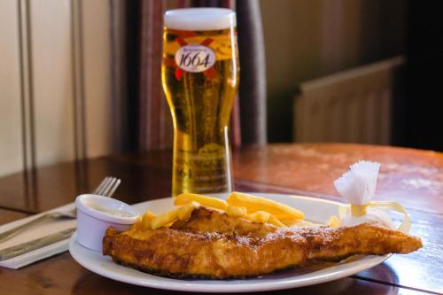 a plate of fish and fries and a glass of beer at The Griffin Belle Hotel Vauxhall in London