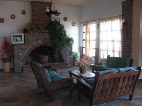 una sala de estar con dos sillas y una chimenea en el Hotel Acquamarina de Villa Gesell