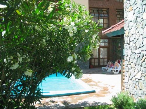 - une piscine dans une cour avec des personnes assises sur une terrasse dans l'établissement Acquamarina Hotel, à Villa Gesell