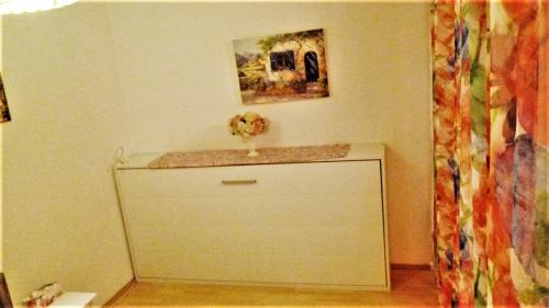 a white cabinet with a vase on top of it at Deutzer Bruecke - CGN Apartments in Cologne