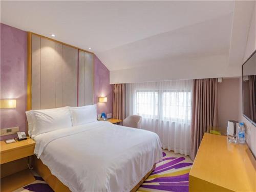 a hotel room with a large bed and a window at Lavande Hotel Zhuhai Gongbei Port Square in Zhuhai