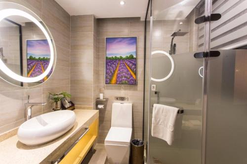 a bathroom with a sink and a toilet and a mirror at Lavande Hotel Suzhou Shilu Changxu in Suzhou