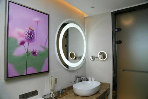 a bathroom with a sink and a mirror on the wall at Lavande hotel suzhou railway station store in Suzhou