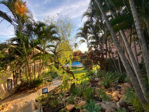 a garden with palm trees and a path at Estalagem Alter Real in Pirenópolis