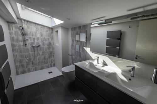 a bathroom with a sink and a toilet and a mirror at Chalet Hygge Saint Lary - gîtes de standing en coeur de village des Pyrénées in Saint-Lary-Soulan