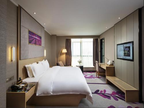 a hotel room with a large bed and a desk at Lavande Hotels·Chengdu Hongpailou Metro Station in Chengdu
