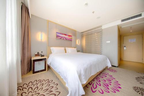 a bedroom with a large white bed and a pink rug at Lavande Hotels·Kunshan Renmin Road in Suzhou