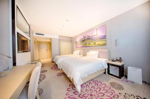 a bedroom with a large white bed and a desk at Lavande Hotels·Kunshan Renmin Road in Suzhou