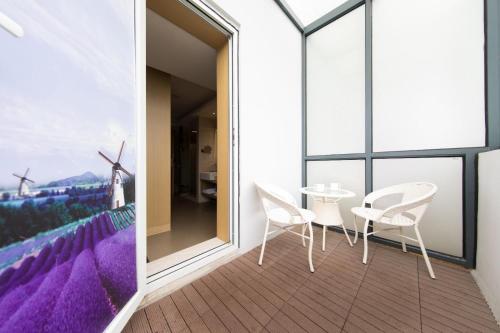 a balcony with white chairs and a table and windmills at Lavande Hotels·Kunshan Renmin Road in Suzhou