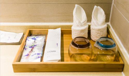 a wooden box with two bottles of wine and shoes at Lavande Hotel Guilin Convention and Exhibition Center in Guilin