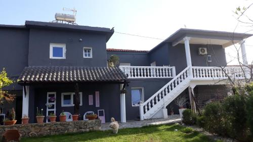 a blue house with a dog in front of it at Garden Rooms in Pírgos Psilonérou