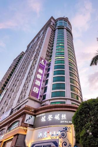 a tall building with a purple sign on it at Lavande Hotels·Guangzhou East Railway Station in Guangzhou