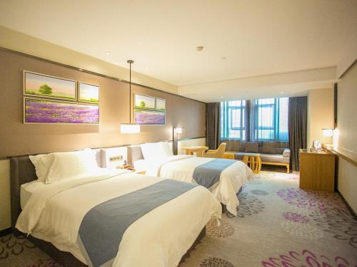a hotel room with two beds and a living room at Lavande Hotels·Guangzhou East Railway Station in Guangzhou