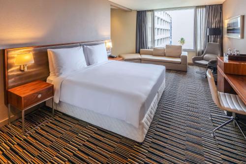 a hotel room with a large bed and a living room at Radisson Blu Okoume Palace Hotel, Libreville in Libreville