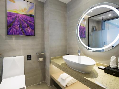 Lavande Hotel Zhangjiajie Tianmenshan Dayongfucheng في تشانغجياجيه: حمام مع حوض ومرآة