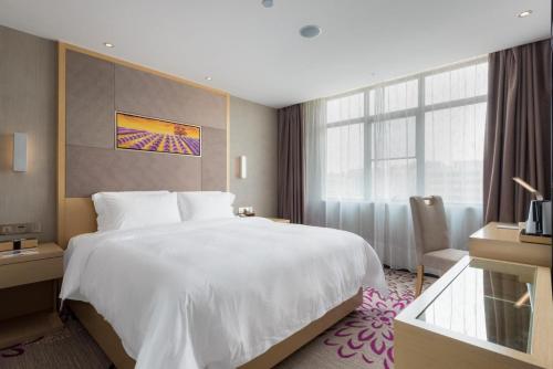 una camera da letto con un grande letto bianco e una finestra di Lavande Hotels·Guangzhou Dongpu Bus Terminal a Canton