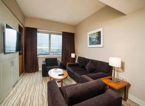 a living room with two couches and a television at Radisson Hotel President Old Town Istanbul in Istanbul