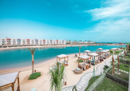 Sunrise Crystal Bay Resort -Grand Select في الغردقة: اطلالة جوية على شاطئ به طاولات و نخيل