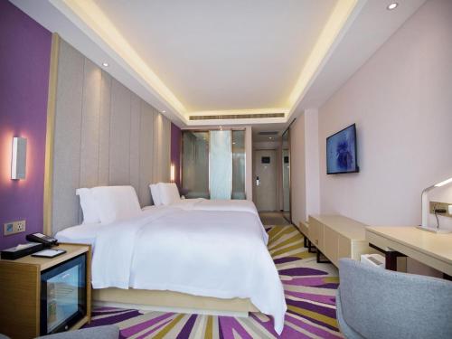 a bedroom with a large white bed and a desk at Lavande Hotel Xi'an Bell Tower in Xi'an