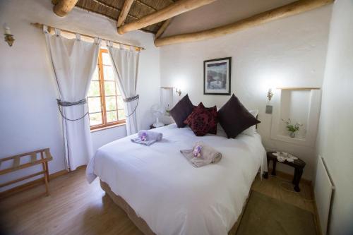 a bedroom with a large white bed with towels on it at Orchard Cottage in McGregor