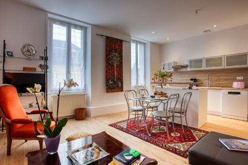 un salon avec une table et des chaises et une cuisine dans l'établissement La licorne sarladaise, à Sarlat-la-Canéda
