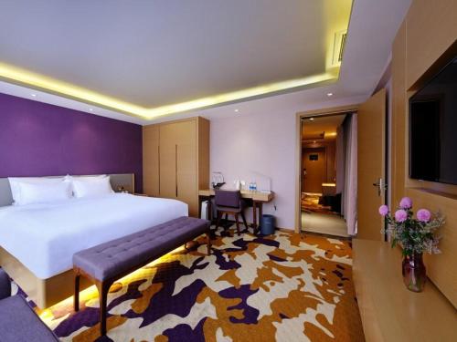 a hotel room with a large bed and a table at Lavande Hotel Chengdu Chunxi Road in Chengdu