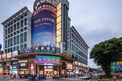 um grande edifício numa cidade com trânsito numa rua em Lavande Hotels·Guangzhou Jingxi Southern Hospital Metro Station em Guangzhou
