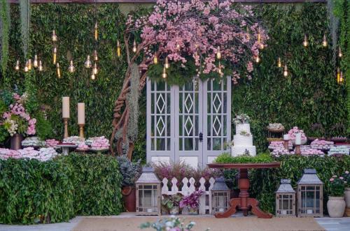 a garden with a white door and flowers and candles at Estalagem Alter Real in Pirenópolis