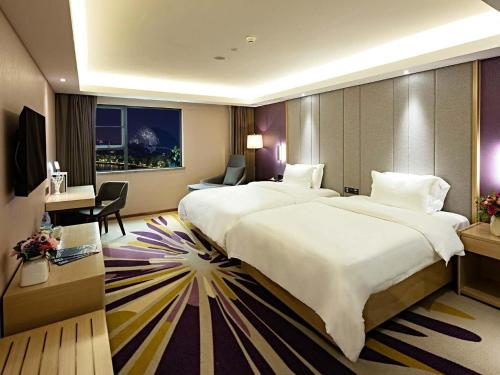 a hotel room with two beds and a desk at Lavande Hotels·Guilin Central Square Elephant Trunk Hill Scenic Area in Guilin