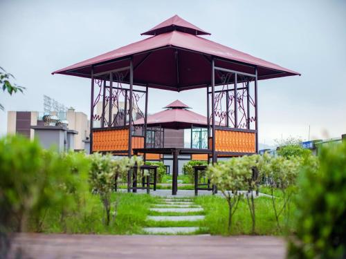 a gazebo with a table and umbrella in a park at Lavande Hotel Chongqing West Station Baguo Cheng in Chongqing