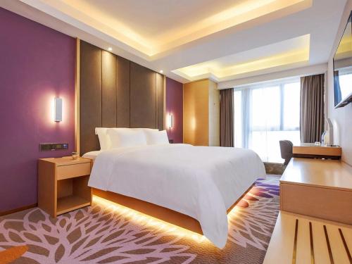 a bedroom with a large white bed and a window at Lavande Hotels·Chongqing Longtoushi North Railway Station in Chongqing