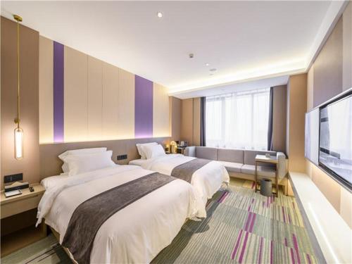 a hotel room with two beds and a flat screen tv at Lavande Hotel Chengdou Qingbai River Phoenix Lake in Chengdu
