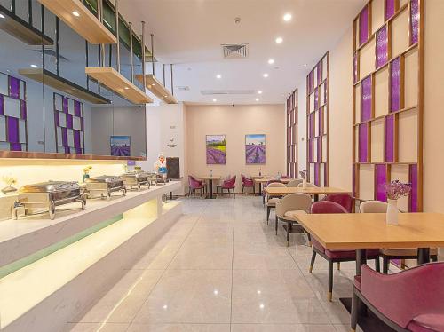 een restaurant met tafels en stoelen en kleurrijke ramen bij Lavande Hotels·Foshan Yanbu Suiyan East Road in Foshan