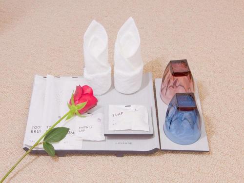a couple of vases and a rose on a table at Lavande Hotels·Nanjing South of Olympic Stadium Daishan New Town in Nanjing