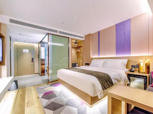 a bedroom with a large white bed and a table at Lavande Hotels·Chongqing Monument for Liberation Haochi Street in Chongqing