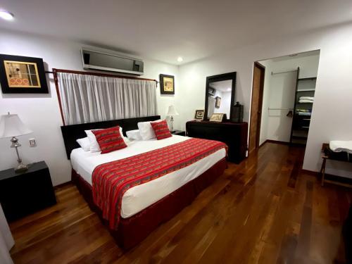 sypialnia z dużym łóżkiem i czerwonym kocem w obiekcie Coras Place Bacalar Lagoon front w mieście Bacalar