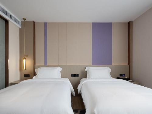 two beds sitting next to each other in a room at Lavande Hotel National Sun Yat-sen University, Zhuhai in Zhuhai